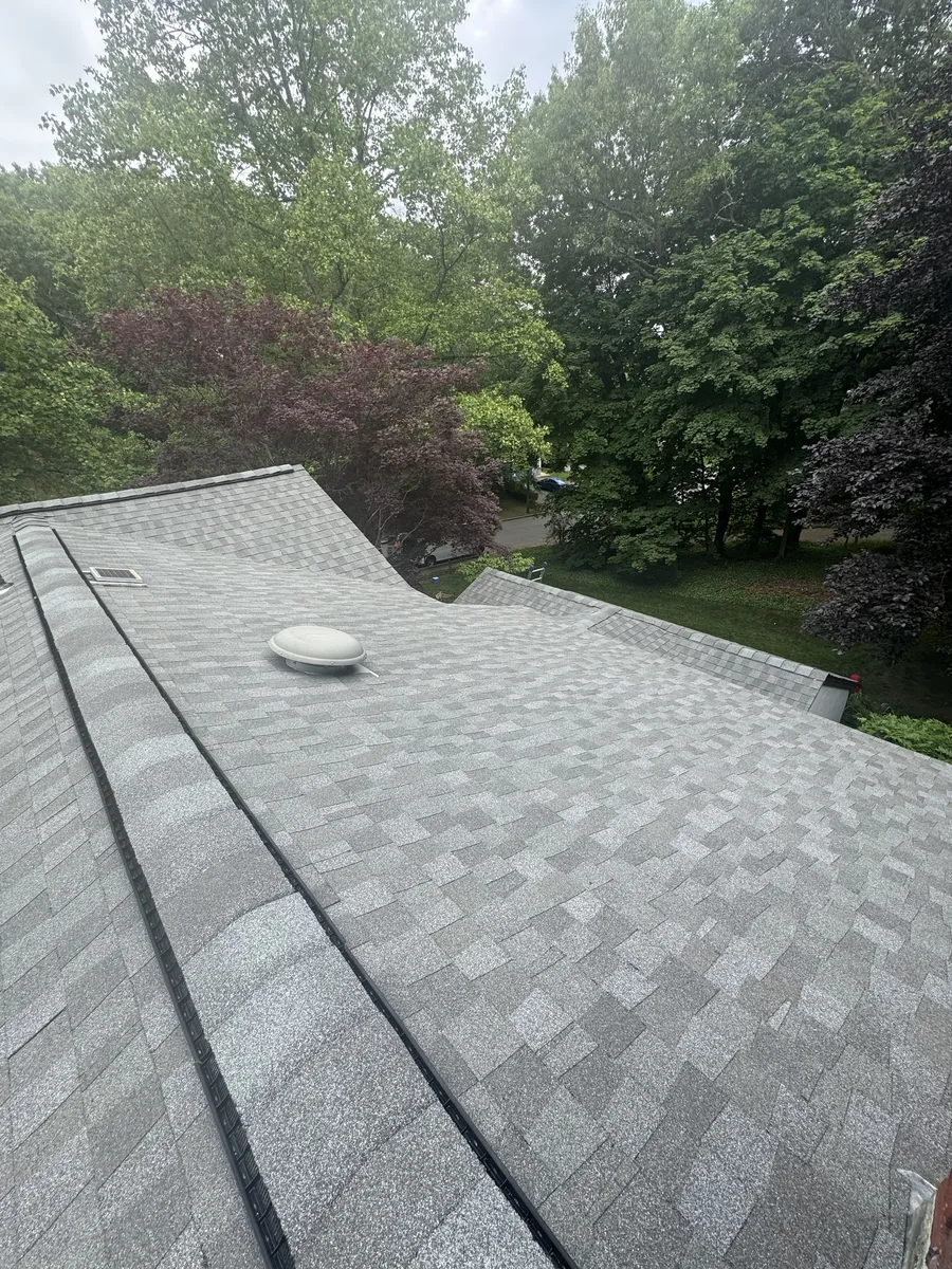 Finished composite shingle roof with a skylight, aerial view