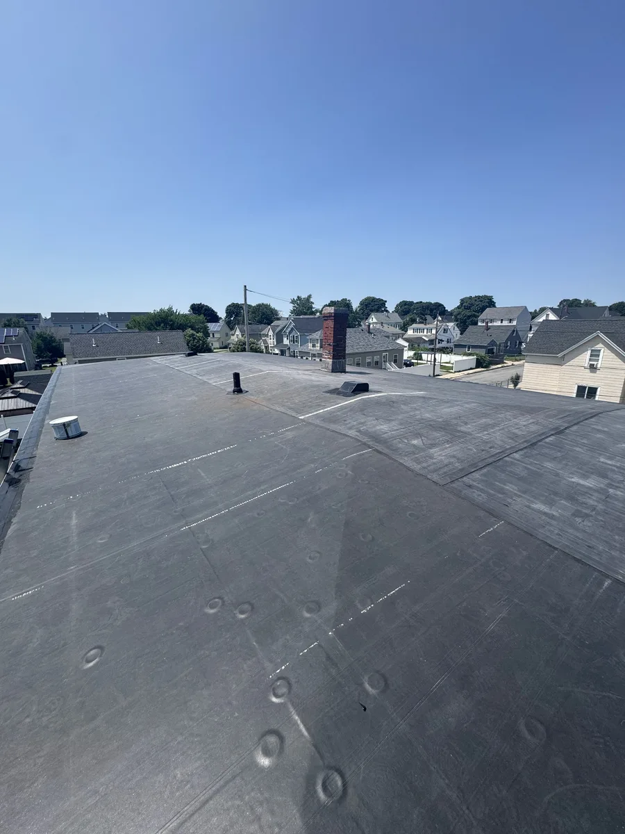 Finished flat roof with chimney, aerial view of a property in Lowell, MA