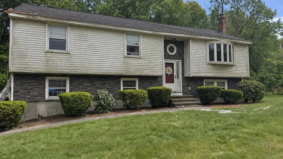 Home exterior in Lowell, MA before the siding replacement, showing the old worn siding