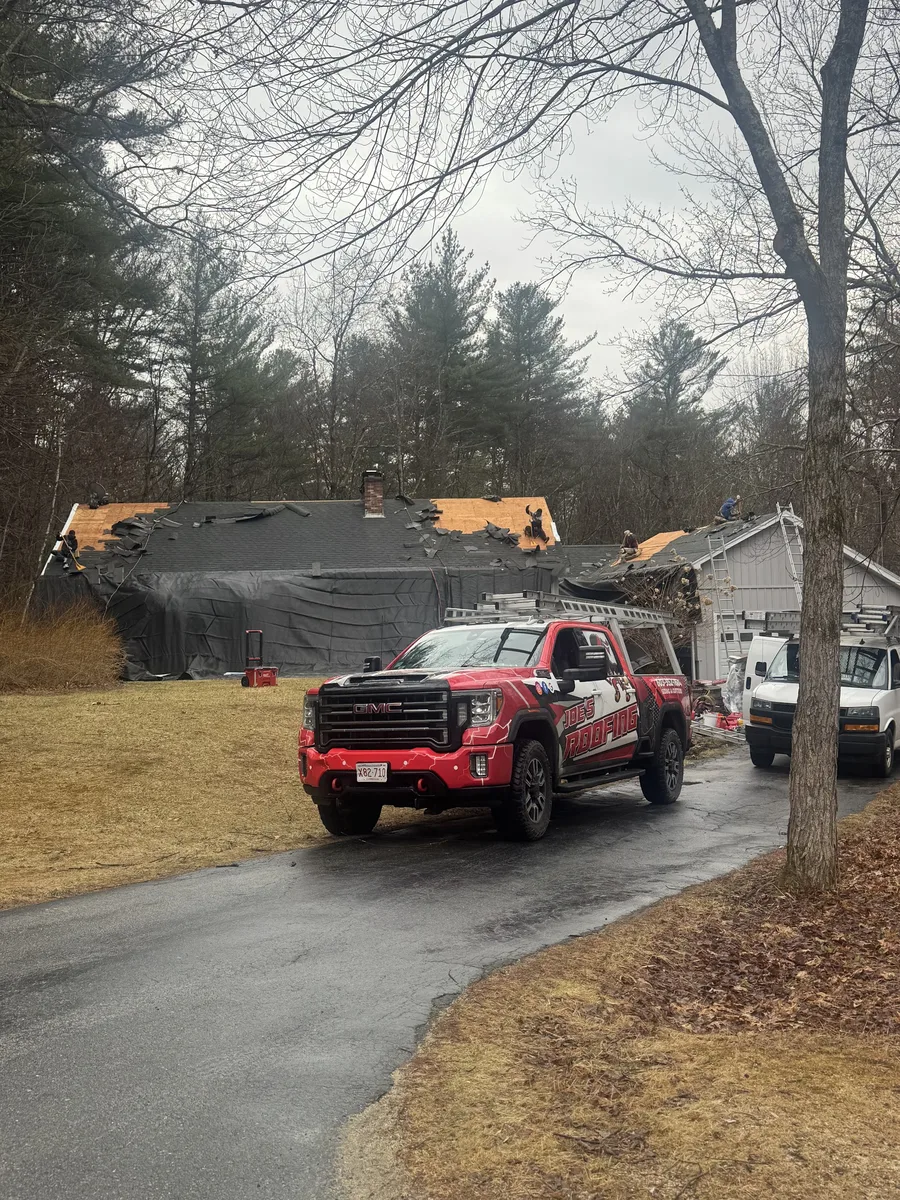 Roofers repairing storm damage on a residential roof