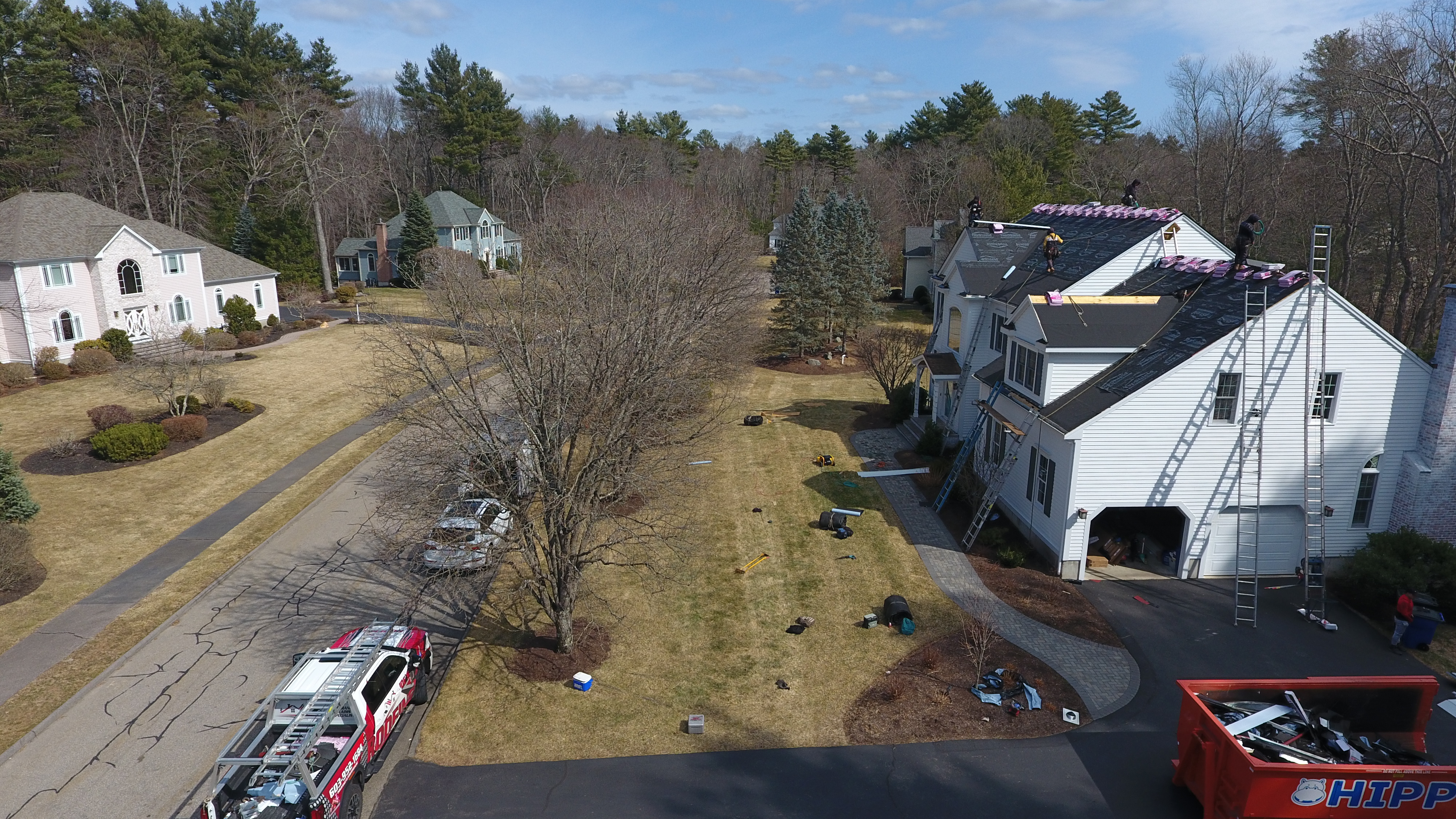 Experienced residential roofers installing composite shingles in New Hampshire neighborhood