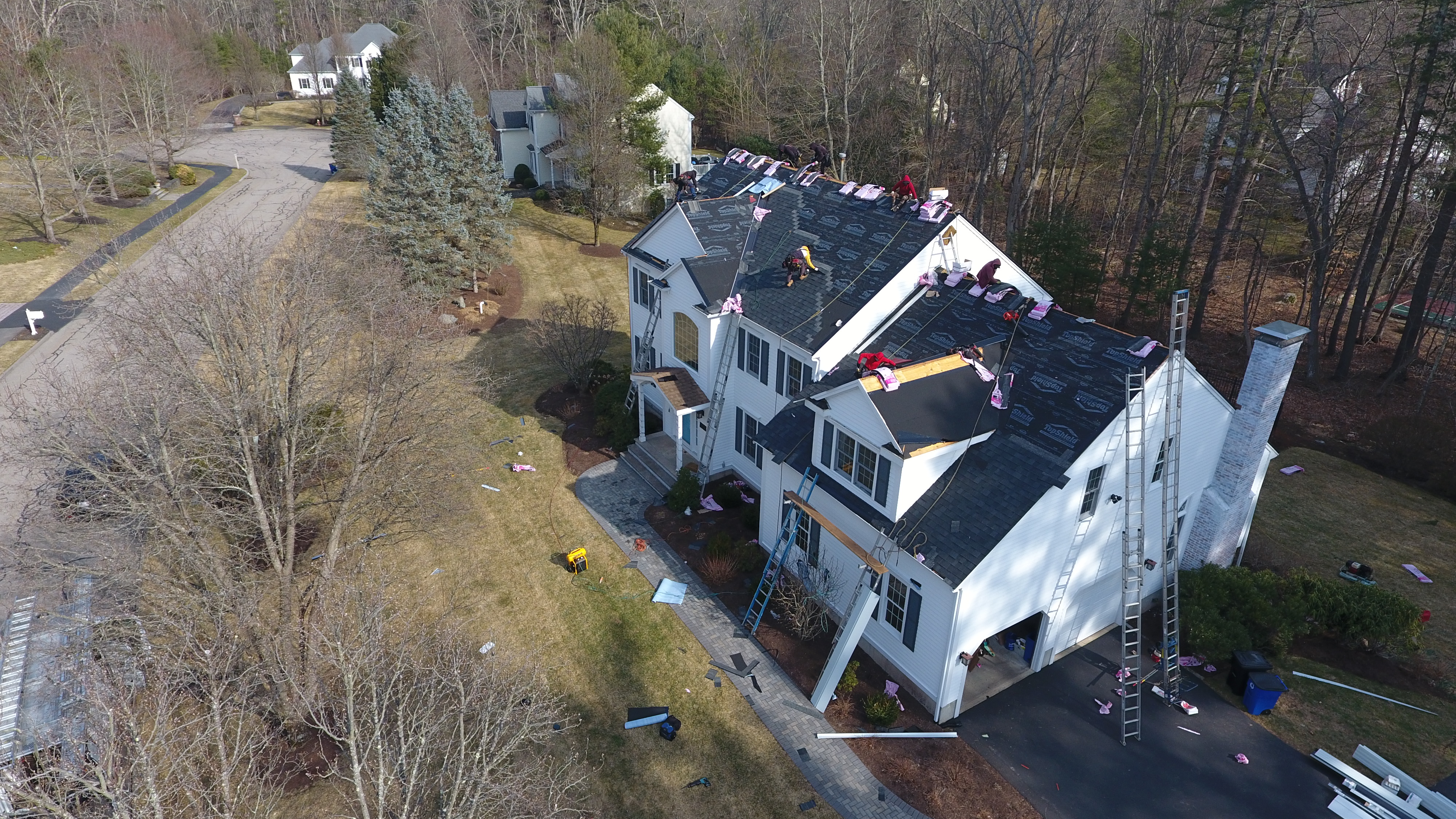Licensed roofers installing proper roof ventilation system in Massachusetts residence