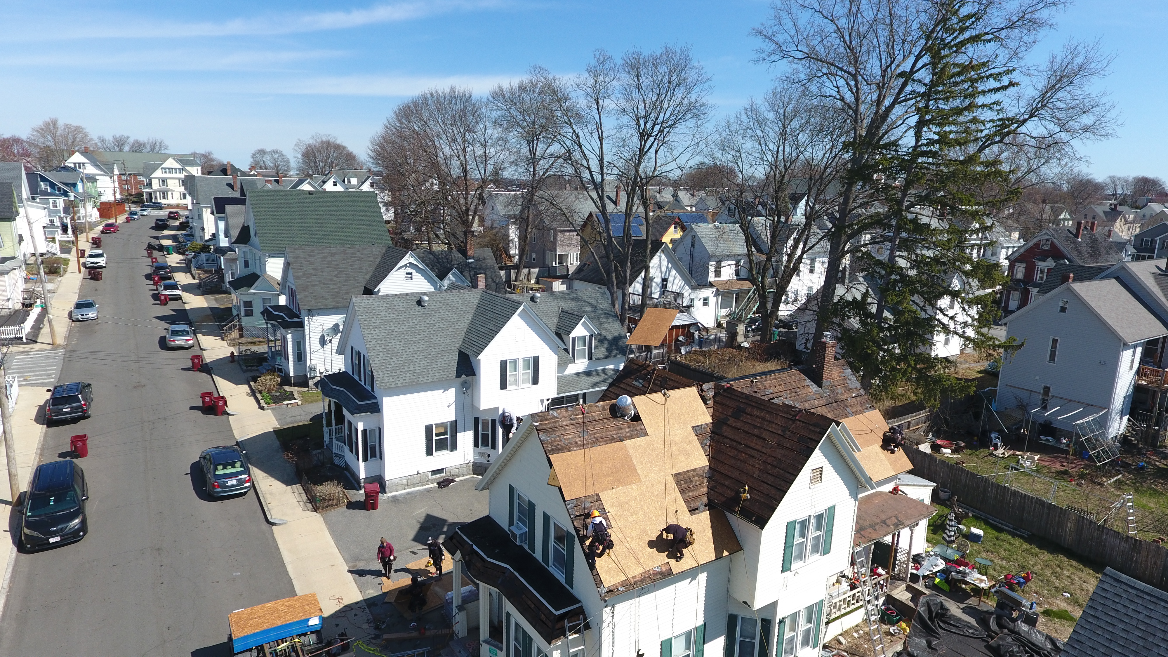 Professional roofing crew working on two-story colonial home in Manchester New Hampshire