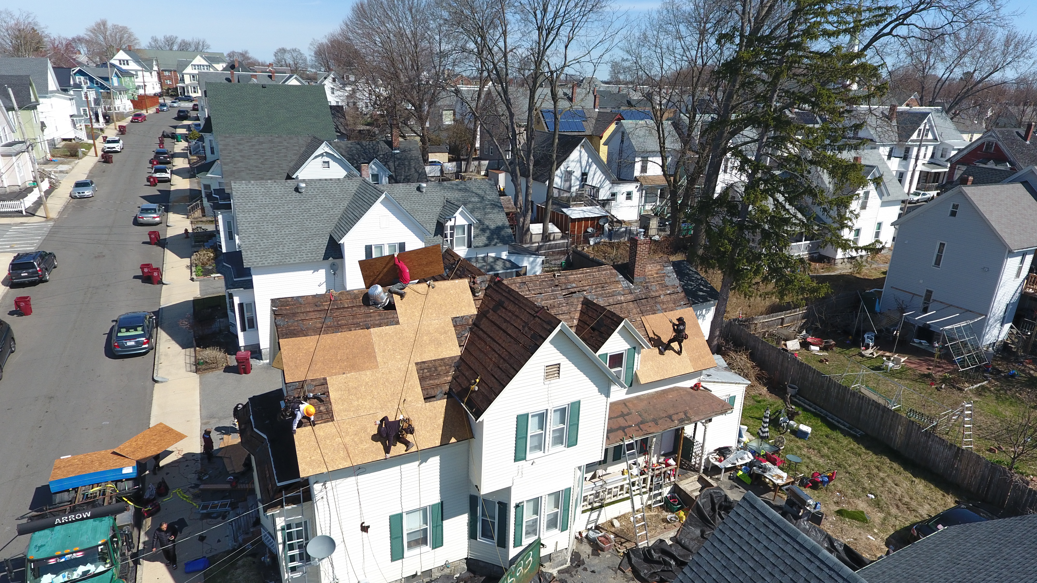 Certified roofers installing ice and water shield underlayment in Massachusetts residential area