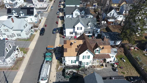 Professional roofer installing new GAF architectural shingles during roof replacement project