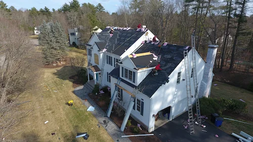 Emergency roof tarping service protecting damaged roof from water during Manchester storm