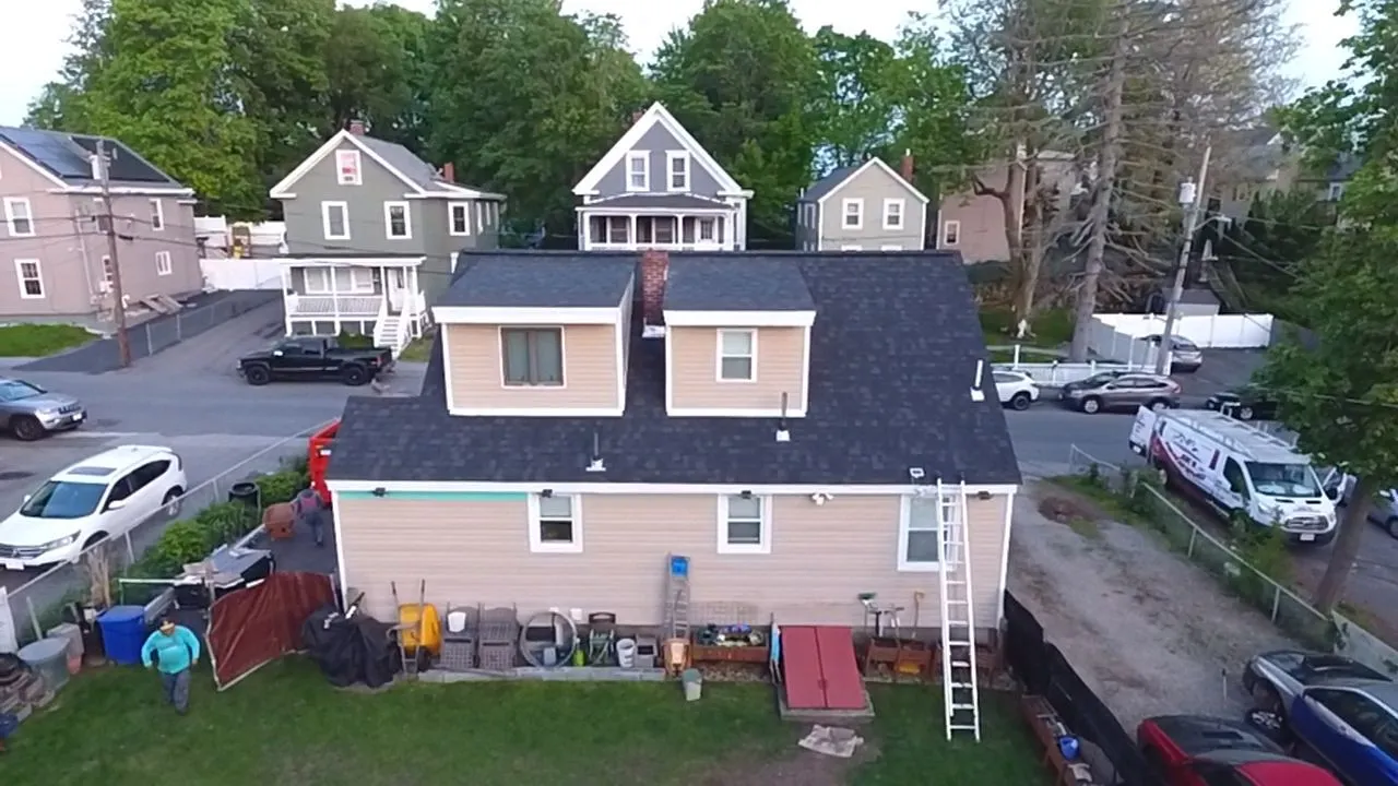 Joe's Roofing crew installing seamless gutters on single-family home in Massachusetts