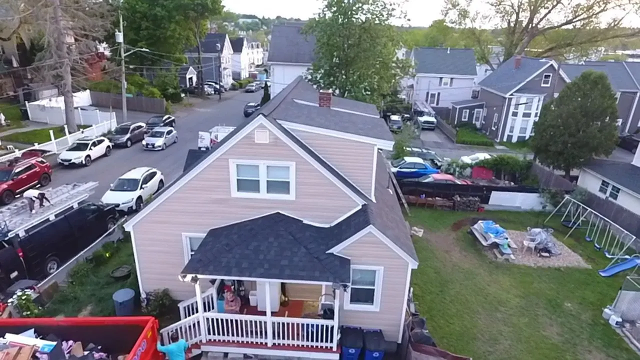 Experienced roofers replacing damaged shingles after storm damage in New Hampshire